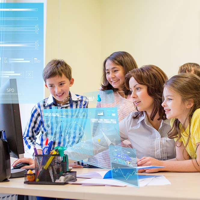 Teacher and students sitting around a computer monitor smiling